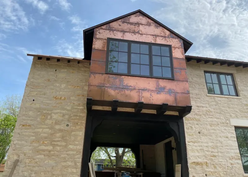 Copper metal panel facade on a stone building for Roof Repair in Diamondhead