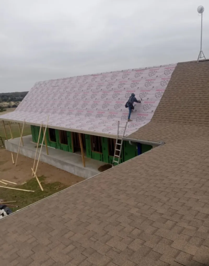 Worker preparing underlayment for a metal roof installation in Diamondhead